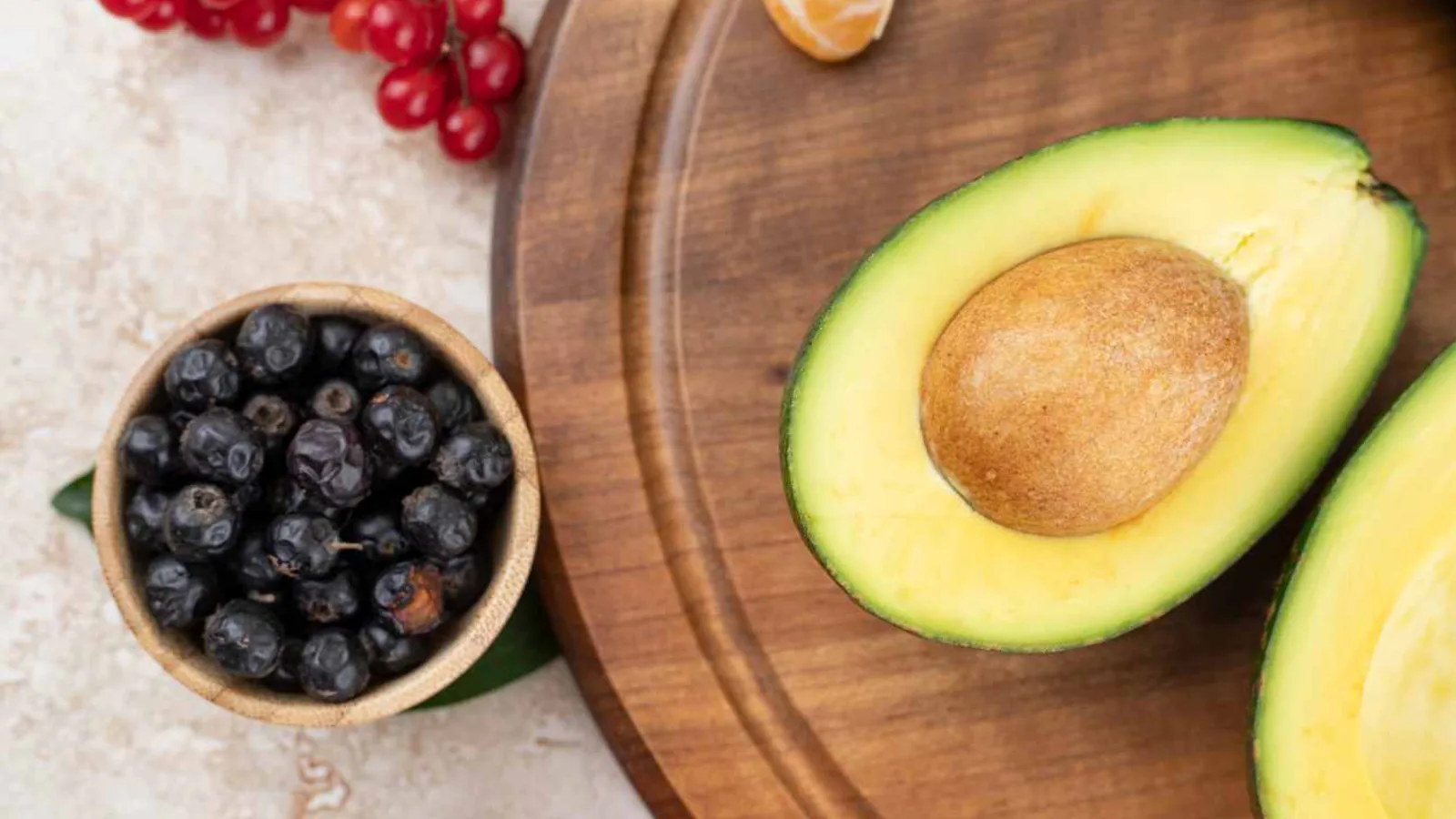 Aguacates y berries dispuestos sobre una superficie de trabajo.