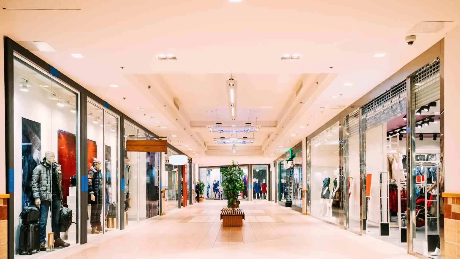 Pasillo interior de un centro comercial con tiendas a ambos lados.